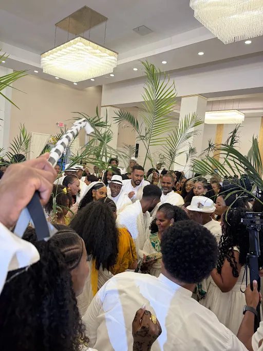 A wedding crowd dressed in white with palm fronds